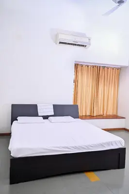 a bedroom with a large bed with a window at Midtown Meadow in Kozhikode
