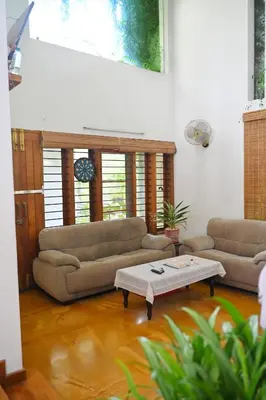 a living room with two couches and a coffee table at Midtown Meadow in Kozhikode