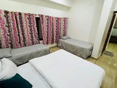 a room with two beds and a window with curtains at LUXE Premium Service Appartment in Mysore