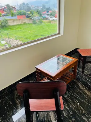 a desk and a chair with a table and a window at Away From Home - 8 - HomeStay, Entire 2 BHK Villa in Ooty