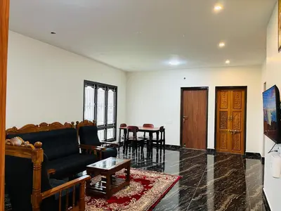 a living room with a couch and a table at Away From Home - 9 - HomeStay, Entire 2 BHK Villa in Ooty