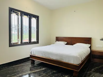 a bedroom with a large bed and two windows at Away From Home - 9 - HomeStay, Entire 2 BHK Villa in Ooty