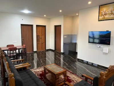 a living room with a couch and a table at Away From Home - 9 - HomeStay, Entire 2 BHK Villa in Ooty