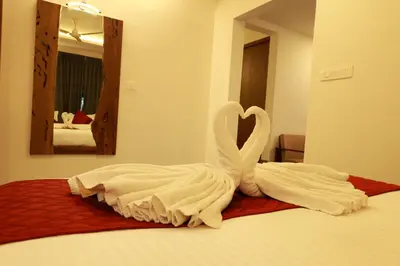 a couple of swans are sitting on a bed at Swiss Holidays in Pinangode