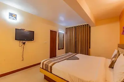 a bedroom with a bed and a tv on the wall at A Ooty Garden Residency in Ooty