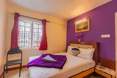 a bedroom with a bed with purple walls and a window at A Ooty Garden Residency in Ooty