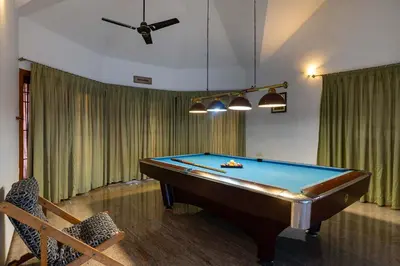 a pool table in a living room with a ceiling at Dwaraka inn -Premium Pool villa and event venue in Coimbatore