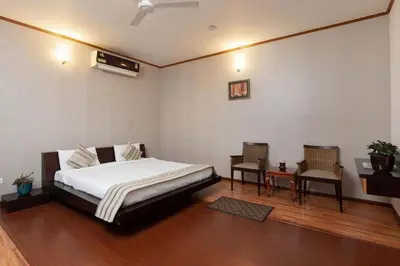 a bedroom with a bed and a table and chairs at Dwaraka inn -Premium Pool villa and event venue in Coimbatore