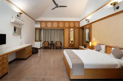 a bedroom with a large bed and a bathroom at Dwaraka inn -Premium Pool villa and event venue in Coimbatore