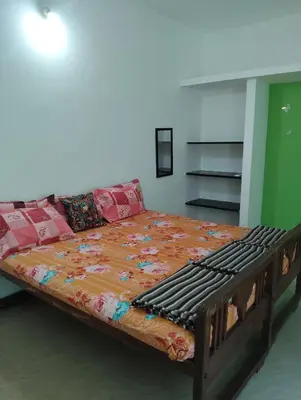 a large bed in a room with a couch at A Cozy Homestay in Coimbatore in Coimbatore