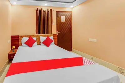 a bedroom with a bed with red and white pillows at Hotel O Sulur Bus Terminal Formerly Sri Sakthi Vinayagar Residency