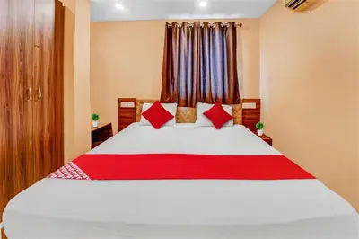 a bedroom with a large white bed with red pillows at Hotel O Sulur Bus Terminal Formerly Sri Sakthi Vinayagar Residency