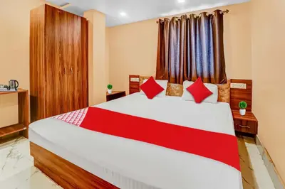 a bedroom with a large bed with red pillows at Hotel O Sulur Bus Terminal Formerly Sri Sakthi Vinayagar Residency