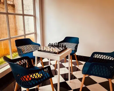 a room with a chess board on a table and chairs at Aura 2Bedroom Duplex Villa with infinity pool in Kalpetta