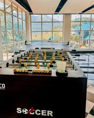 a large pool table in a room with windows at Aura 2Bedroom Duplex Villa with infinity pool in Kalpetta