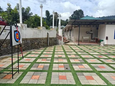 an outdoor area with a stone wall and green grass at AppleLand City Athirapilly by Hotels Cart in Athirappally