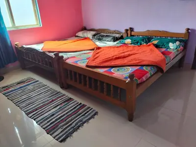 a bedroom with two beds with orange sheets at Laali Penthouse in Madikeri
