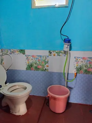a bathroom with a toilet and a bucket at Laali Penthouse in Madikeri