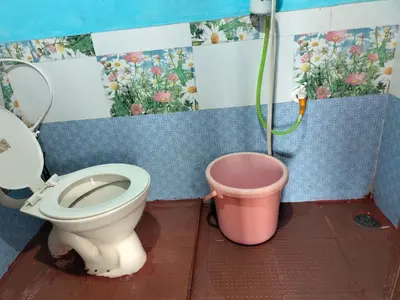 a bathroom with a toilet and a bucket at Laali Penthouse in Madikeri