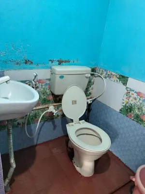 a bathroom with a toilet and a sink at Laali Penthouse in Madikeri