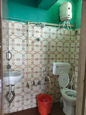 a bathroom with a toilet and a sink at Laali Dormitory in Madikeri