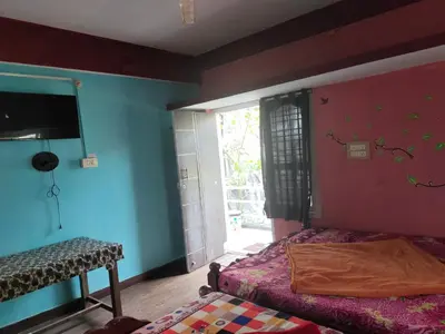 a bedroom with blue and red walls and a bed at Laali Dormitory in Madikeri