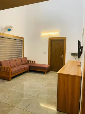 a living room with a couch and a desk in it at The Soul 1 Service Villa in Mananthavady