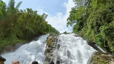 a waterfall in the middle of a river at Pavans Rainy Days Home Stay in Athirappilly
