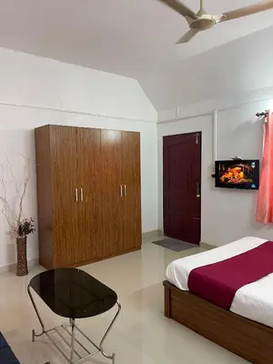 a bedroom with a bed and a tv on the wall at Wayanad Midnight Farmhouse in Sultan Bathery