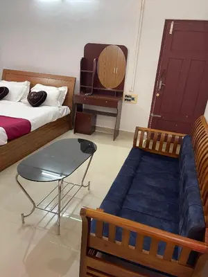 a bedroom with two beds and a table and a chair at Wayanad Midnight Farmhouse in Sultan Bathery