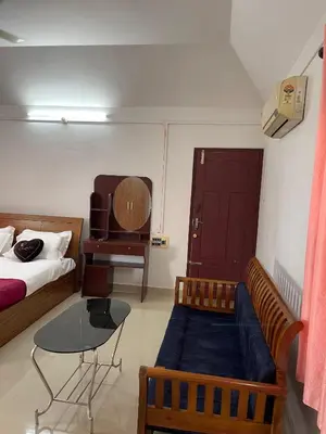 a bedroom with a couch and a table and a bed at Wayanad Midnight Farmhouse in Sultan Bathery