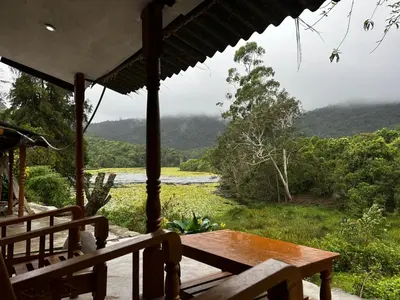 a porch with a table and a view of a river at Nirvana 'By the lake' in Kūkkāl