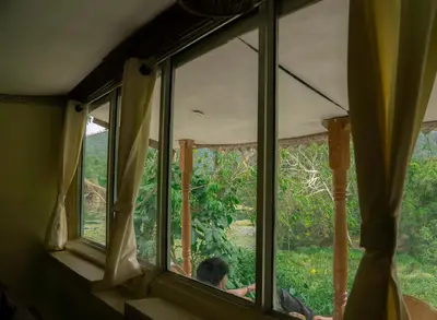 a man looking out the window of a house at Nirvana 'By the lake' in Kūkkāl