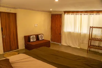 a bedroom with a bed and a chair in it at Nirvana 'By the lake' in Kūkkāl