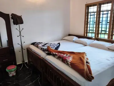 a bedroom with a bed with a blanket on it at Palm view 2 in Kanthalloor