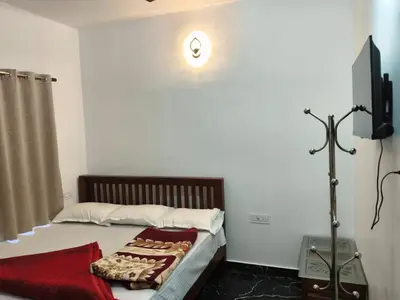 a bedroom with a bed with a tv on the wall at Palm view 2 in Kanthalloor