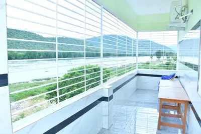 a room with a large window with a view of the water at CS RESORT River point in Wodapatti