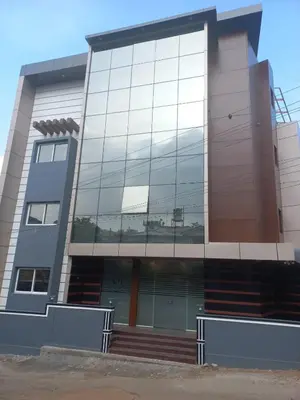 a large building with glass windows on the side at SUROOR Recidency in Virajpet