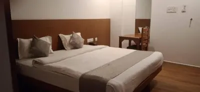 a bedroom with a large bed with a wooden headboard at SUROOR Recidency in Virajpet