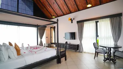 a bedroom with a large bed and a table at Manjoora Saddles Resorts & Spa in Padinjarathara