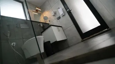 a bathroom with a mirror and a sink at Manjoora Saddles Resorts & Spa in Padinjarathara