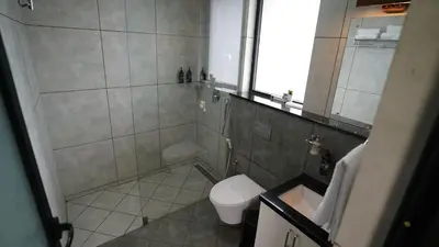 a bathroom with a shower and a toilet and a window at Manjoora Saddles Resorts & Spa in Padinjarathara