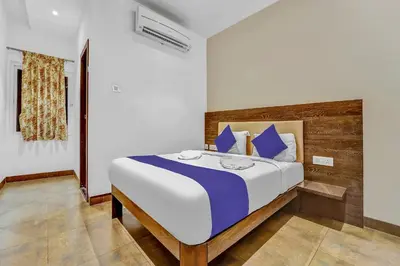 a bedroom with a large bed with blue pillows at Hotel Karpagam Lodging House Nr Railway Station & Gandhipuram bus stand in Coimbatore