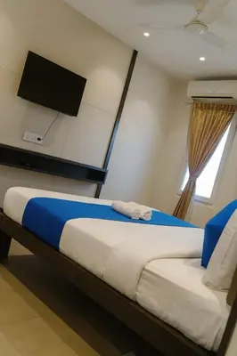 a bedroom with a bed with a tv on the wall at Hotel Karpagam Lodging House Nr Railway Station & Gandhipuram bus stand in Coimbatore
