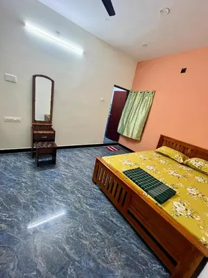 a bedroom with a bed and a mirror at Athithi AC Studio Flat By Shivalaya Stays in Podanūr