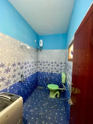 a blue bathroom with a green toilet in it at Athithi AC Studio Flat By Shivalaya Stays in Podanūr