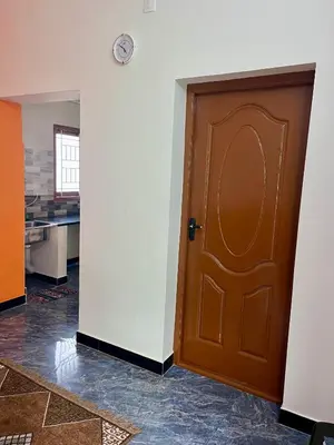 a wooden door in a room with a kitchen at Athithi AC Studio Flat By Shivalaya Stays in Podanūr