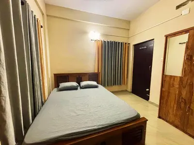 a bedroom with a large bed in a room at Saraa Homes Fully Furnished 2BHK Apartment in Kulattūr