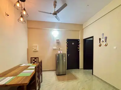 a dining room with a refrigerator and a table at Saraa Homes Fully Furnished 2BHK Apartment in Kulattūr