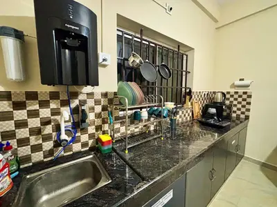 a kitchen with a sink and a counter top at Saraa Homes Fully Furnished 2BHK Apartment in Kulattūr